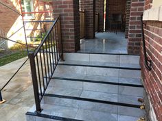 a set of stairs leading up to a brick building with metal railings and handrails