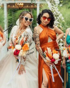 two women in orange dresses standing next to each other