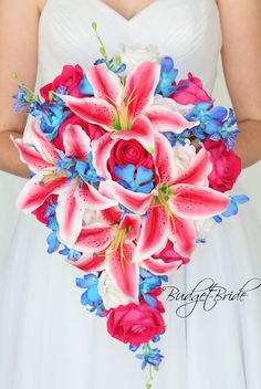 a bride holding a bouquet of pink and blue flowers