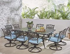 an outdoor dining table with blue chairs and potted plants