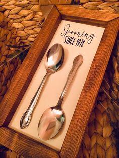 two spoons and a spoon rest in a shadow box with the words serving since wed written on it