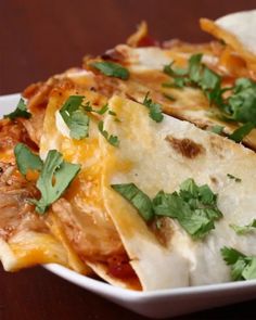 two quesadillas in a white dish on a wooden table