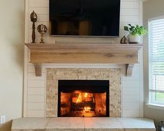 a living room with a fire place and television above the fireplace in front of it