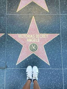 a person standing in front of a star on the hollywood walk of fame with their feet up