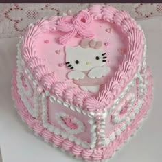 a hello kitty heart shaped cake with pink frosting