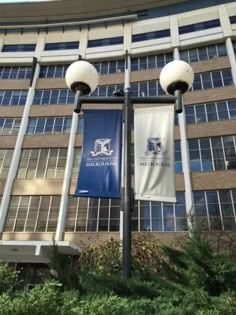 two street lamps are in front of a building