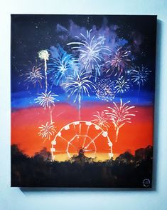 fireworks are lit up in the sky above a ferris wheel