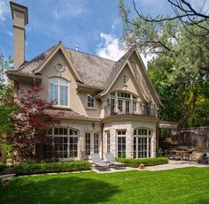 a large house sitting in the middle of a lush green yard with lots of trees