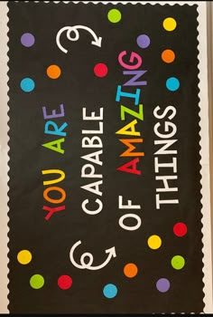 a black bulletin board with multicolored polka dots and the words, you are amazing