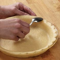 a person using a spoon to make pie crusts