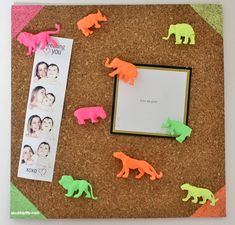 a cork board with different colored elephants on it and a photo frame next to it