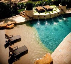 an outdoor swimming pool with lounge chairs next to it