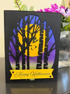 a happy halloween card on a table with flowers