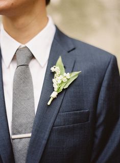 a man in a suit and tie with a boutonniere on his lapel