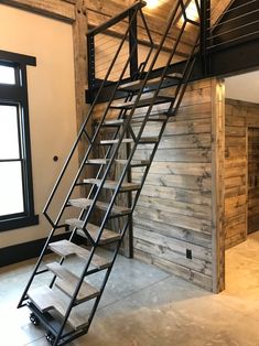 a metal stair case sitting inside of a room next to a window on the wall