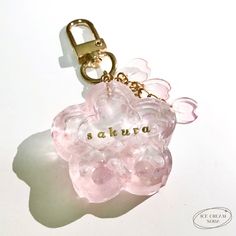 a keychain with a pink flower and the word akura written on it