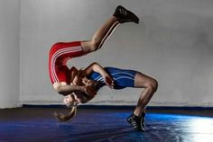 two men are doing acrobatic tricks on the floor