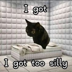 a black cat sitting on top of a mattress in a room with white tile walls