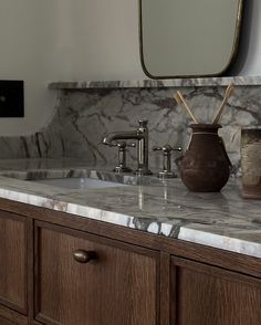 a bathroom with marble counter tops and wooden cabinets