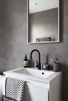 a white sink sitting under a bathroom mirror