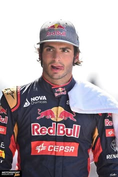 a man wearing a red bull racing uniform