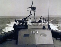 a black and white photo of a boat in the water with an american flag on it