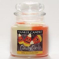 an orange and white candle with jack - o'- lanterns on it sitting in front of a white background