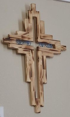 a cross made out of wooden planks with eyes painted on the front and sides