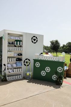 an outdoor display with soccer themed items on the side and people sitting in chairs behind it