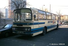 a bus is parked next to a car on the street