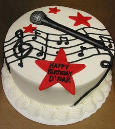 a birthday cake decorated with musical notes and a microphone