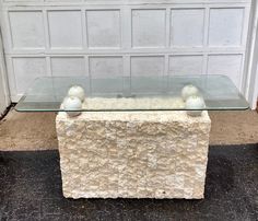 a glass table with two balls on it in front of a garage door and white doors