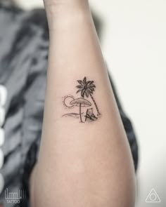 a small palm tree tattoo on the arm