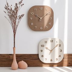 a clock on the wall next to a vase with flowers and an egg in it