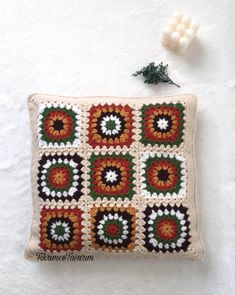 a crocheted pillow is sitting on a white surface