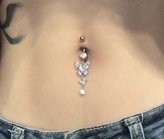 a woman's stomach with a diamond belly ring attached to the bottom of it