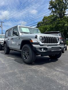 two jeeps are parked in a parking lot