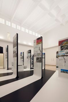 an empty room with multiple displays on the wall and black and white stripes in the floor