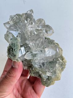 a person holding some kind of rock with crystals on it's sides and in their hand