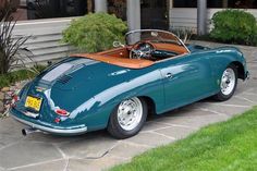 a blue sports car parked in front of a building with a tan leather seat cover