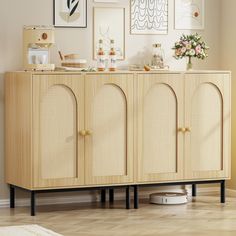 a sideboard with wicker doors and pictures on the wall