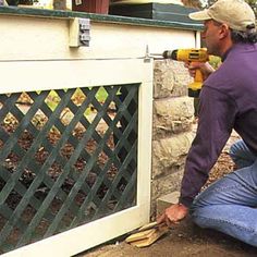 a man using a drill to fix a gate