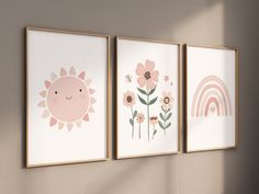 three framed art prints hanging on the wall in a child's room with sun, flowers and rainbows