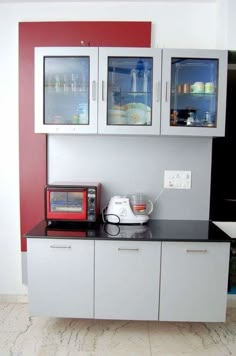 a kitchen area with cabinets, microwave and toaster oven on top of the counter