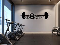 there is a wall sign that says crossfit in the middle of a gym