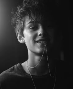 black and white photograph of a young man with chain around his mouth