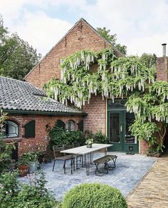 an outdoor patio with table and chairs surrounded by greenery