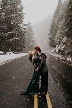 a couple kissing in the middle of a snowy road