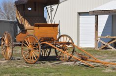 an old fashioned horse drawn carriage parked in front of a building