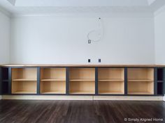 an empty room with wooden shelves and hard wood flooring